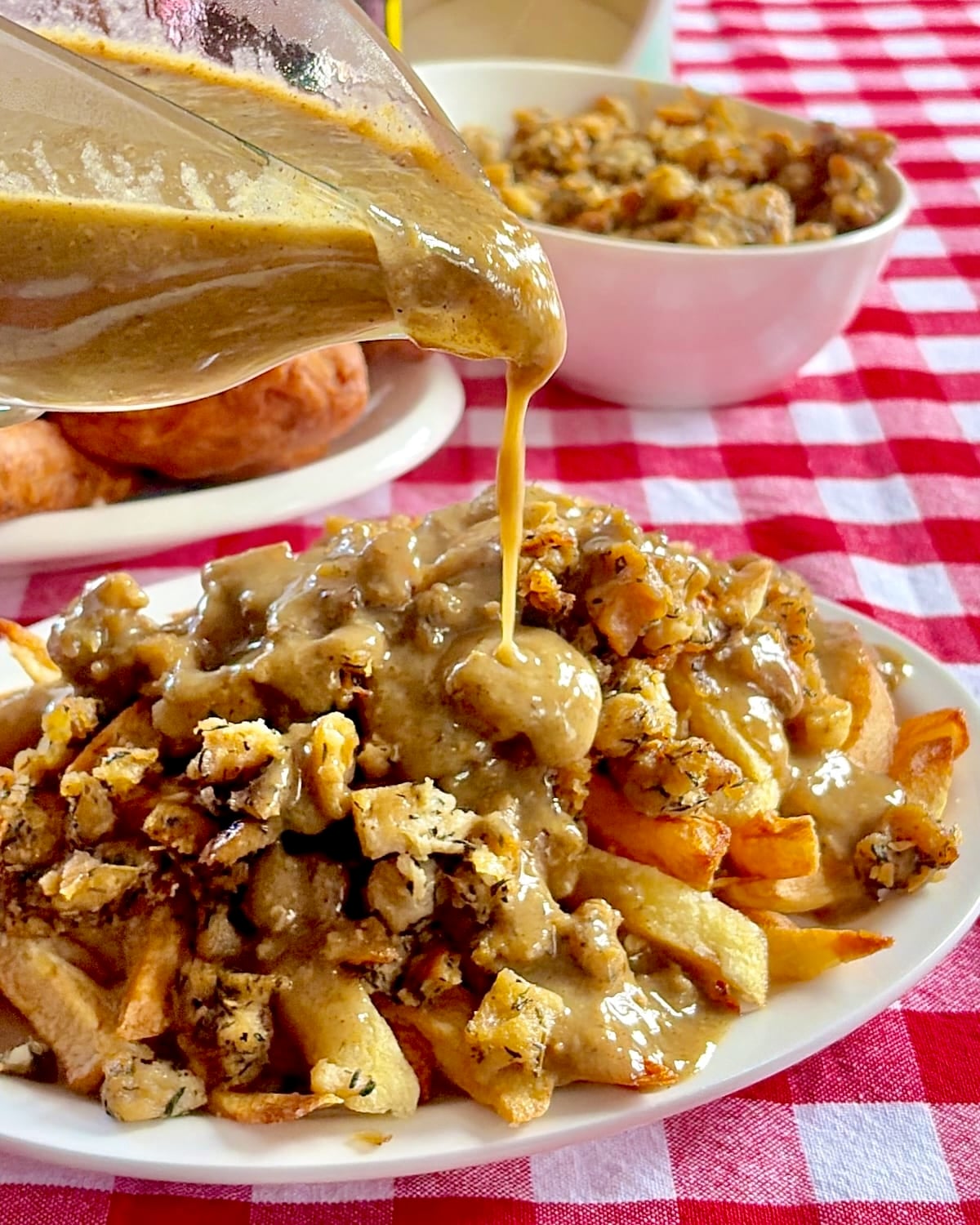 Photo of gravy being poured into french fries topped with Newfoundland dressing.