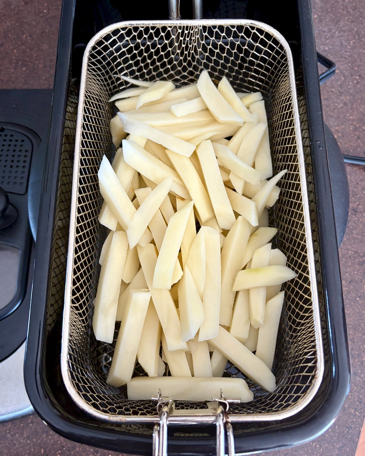 Photo of Cold Oil French Fries in a fryer basket.