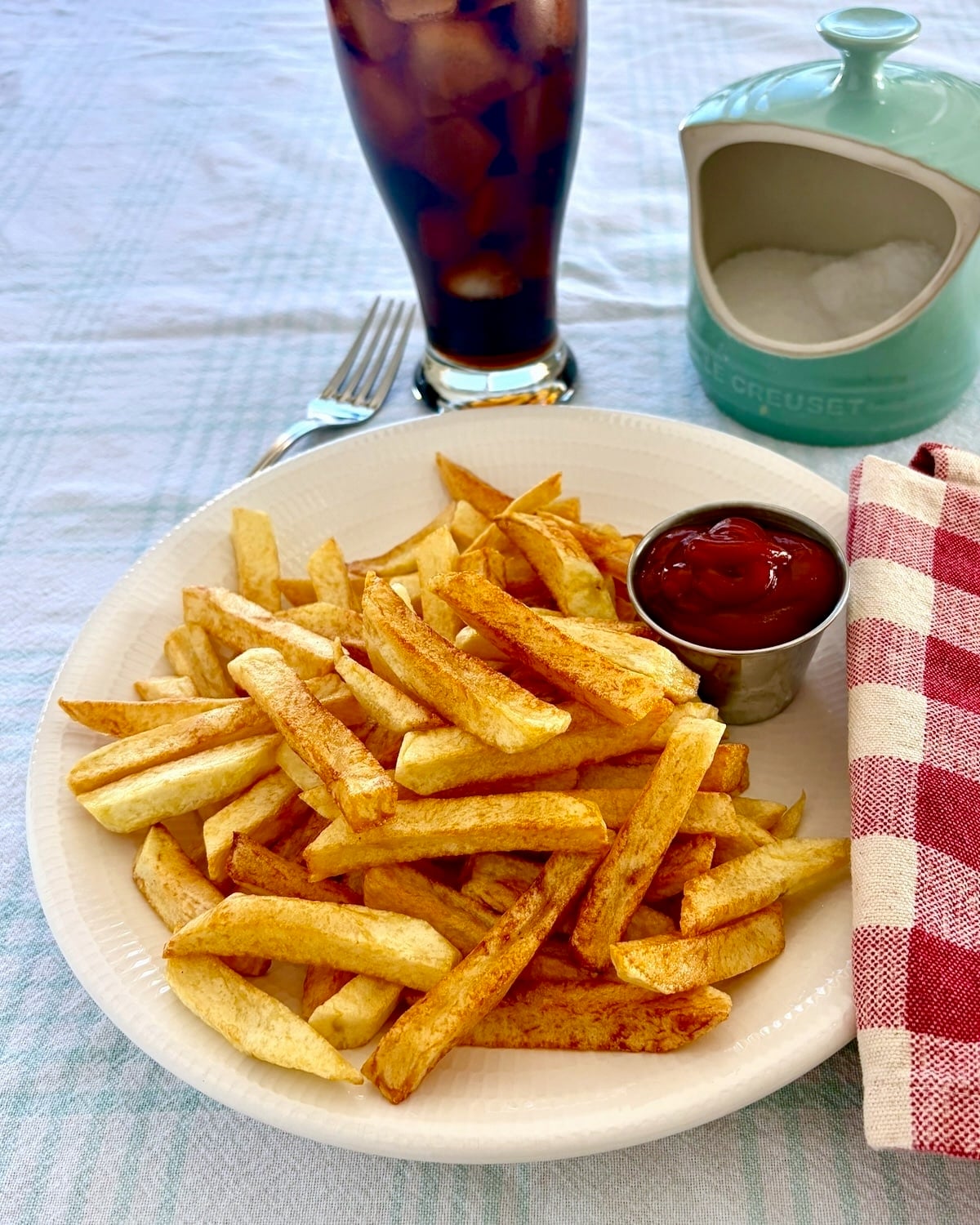 Cold Oil French Fries shown with a ice cold soda and ketchup for dipping.