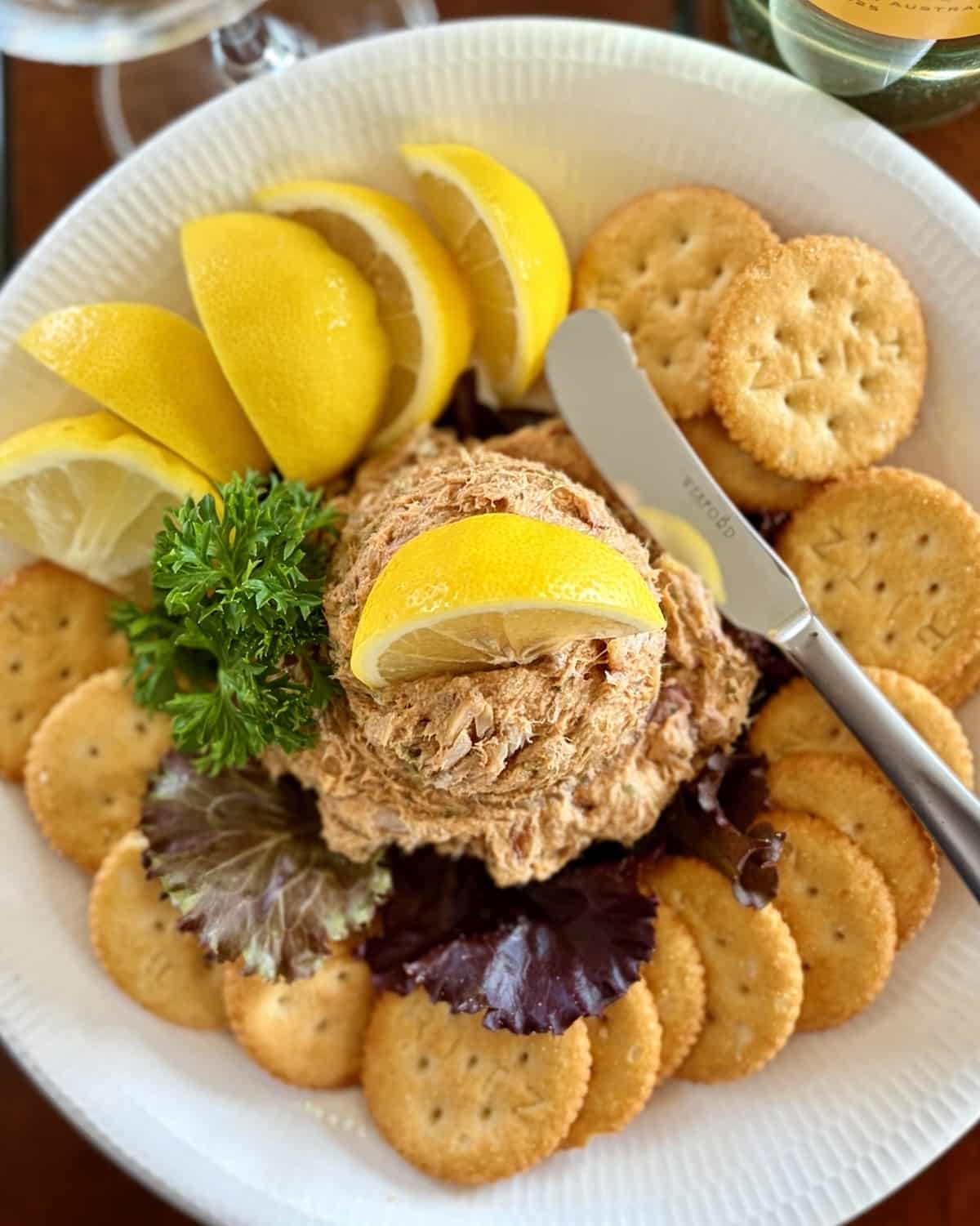Overhead shot of a scoop of Smoked Fish Dip served as an appetizer with lemon slices and Ritz Crackers.