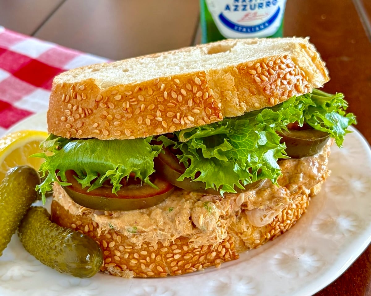 Close up photo of smoked fish Dip Sandwich with Heirloom tomatoes and curly lettuce.