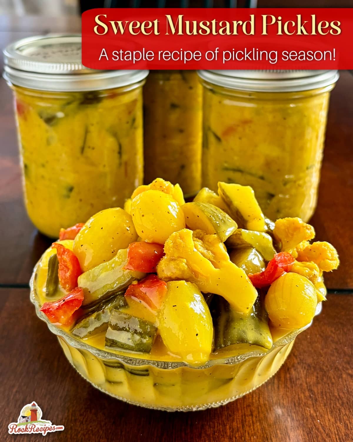 Newfoundland Mustard Pickles photo of mixed pickles in an antique clear glass serving dish with bottles of finished pickles in the background. Photo has title text and Rock Recipes logo added for Pinterest and social media posts.