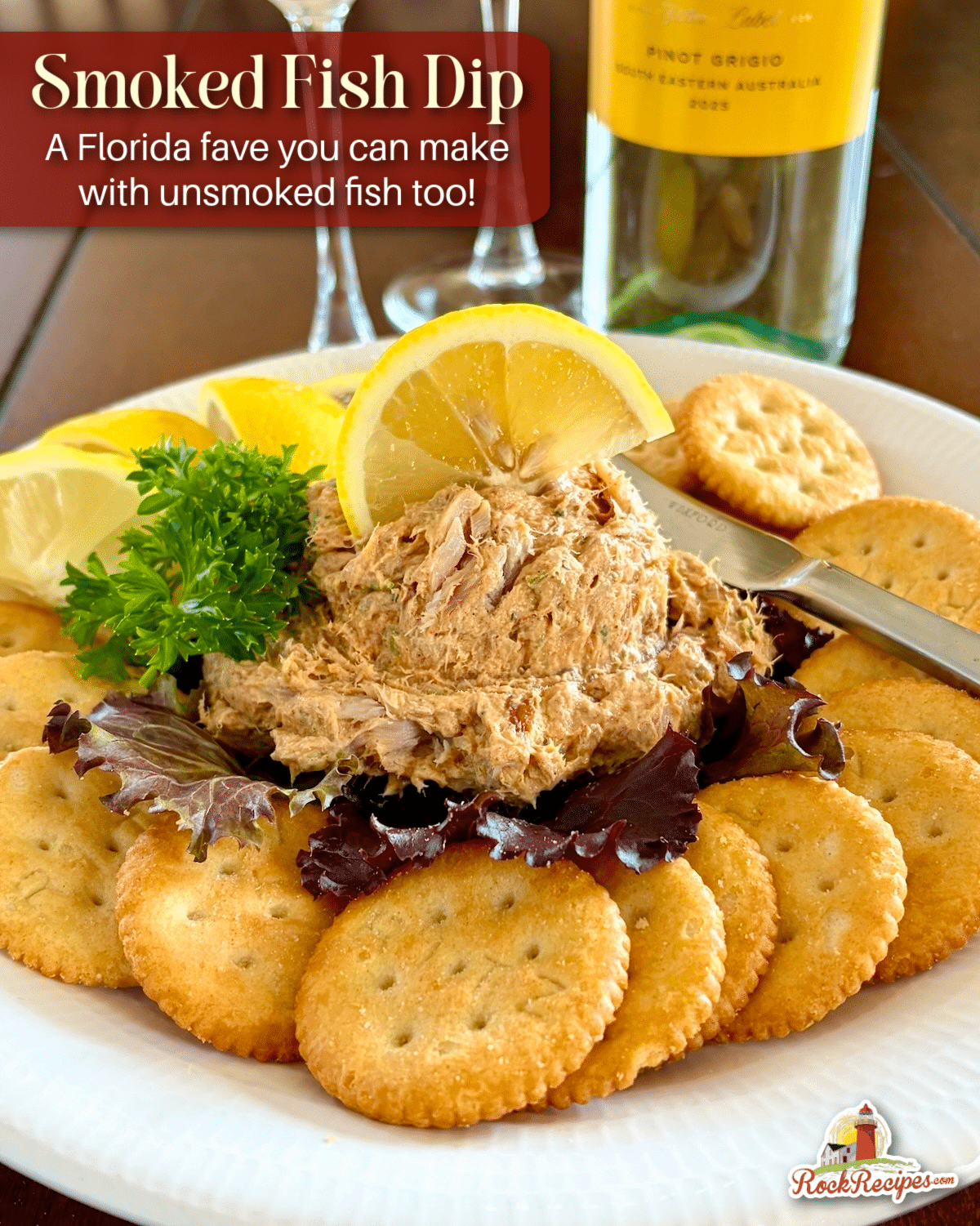 Close up photo of a scoop of Smoked Fish Dip served as an appetizer with lemon slices and Ritz Crackers. This photo has the post title text and Rock Recipes logo added for Pinterest and social media posts.