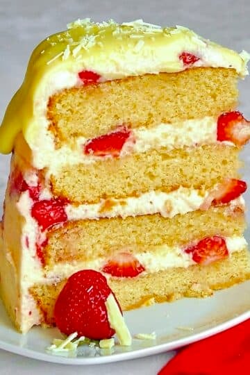 One slice if Strawberry White Chocolate Buttercream Cake on a white plate.