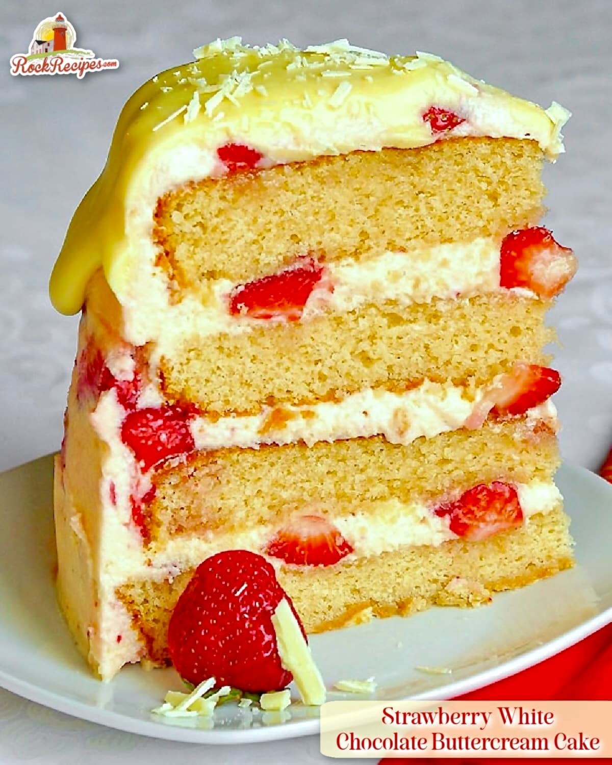One slice of Strawberry White Chocolate Buttercream Cake on a white plate with title text added for PINTEREST AND SOCIAL MEDIA POSTS.