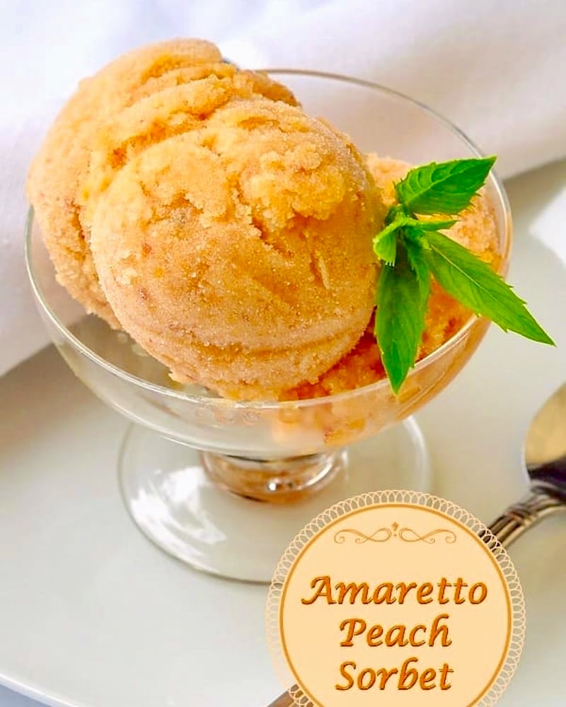 Amaretto Peach Sorbet, photo of one serving in a clear glass pedestal dessert dish with title text added for social media posts.