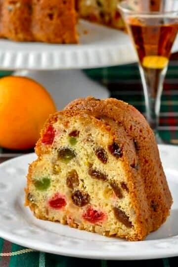 Orange Brandy Fruitcake photo of one slice on a white plate.