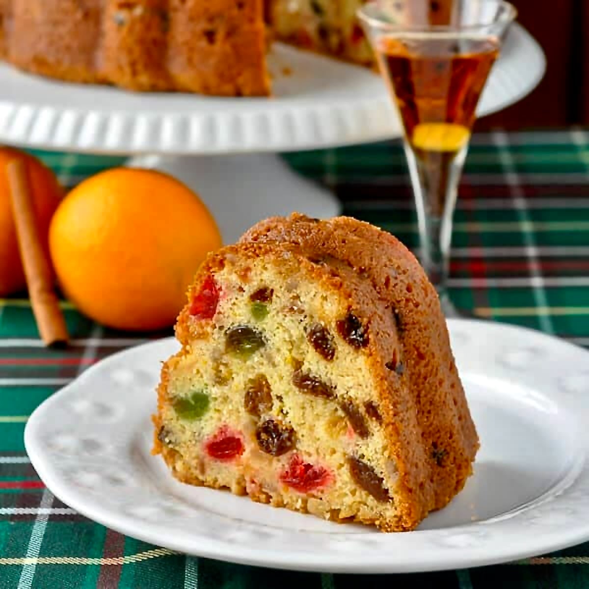Orange Brandy Fruitcake photo of one slice on a white plate.