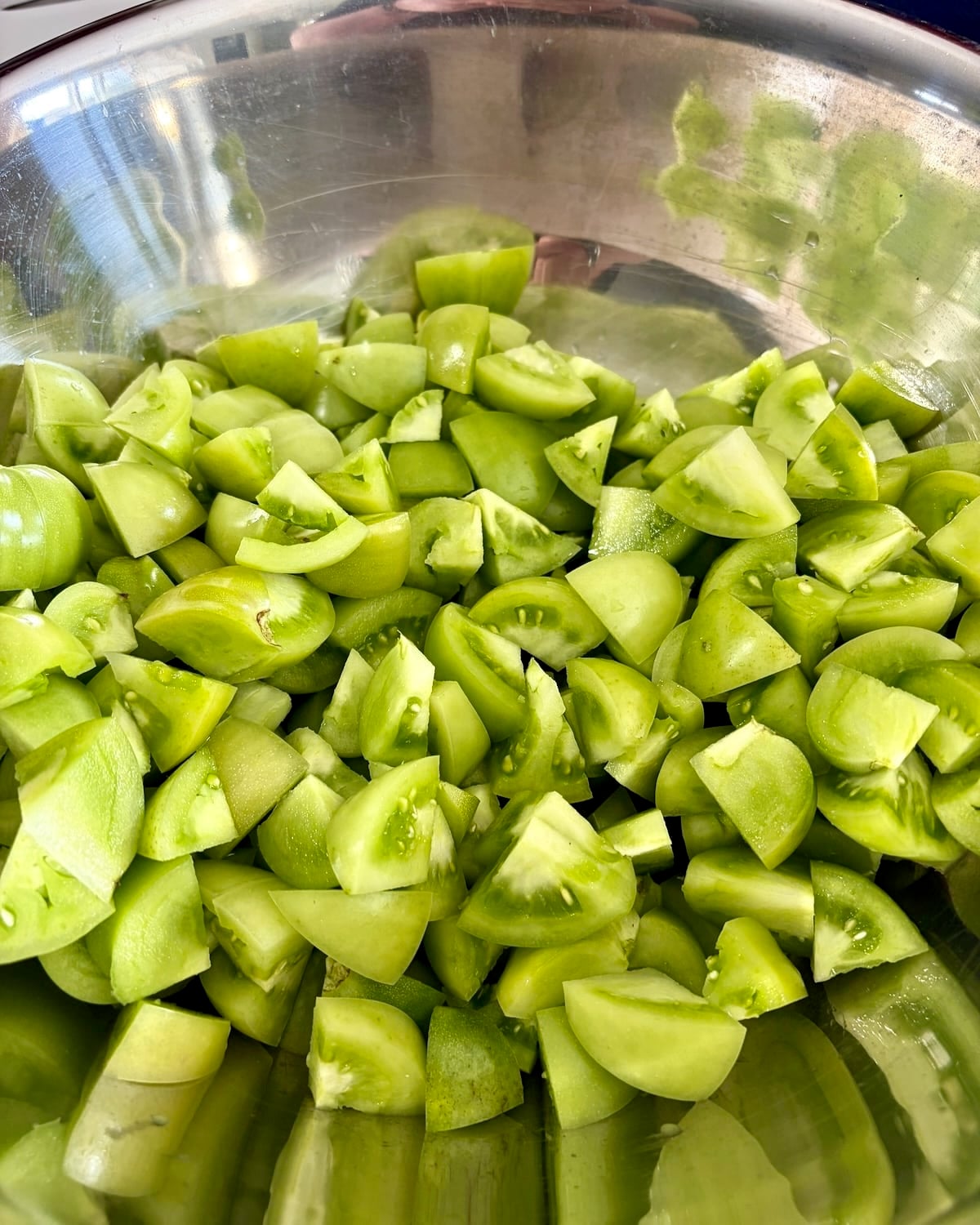 Photo of Chopped Green Tomatoes in a stainless steel bowl.