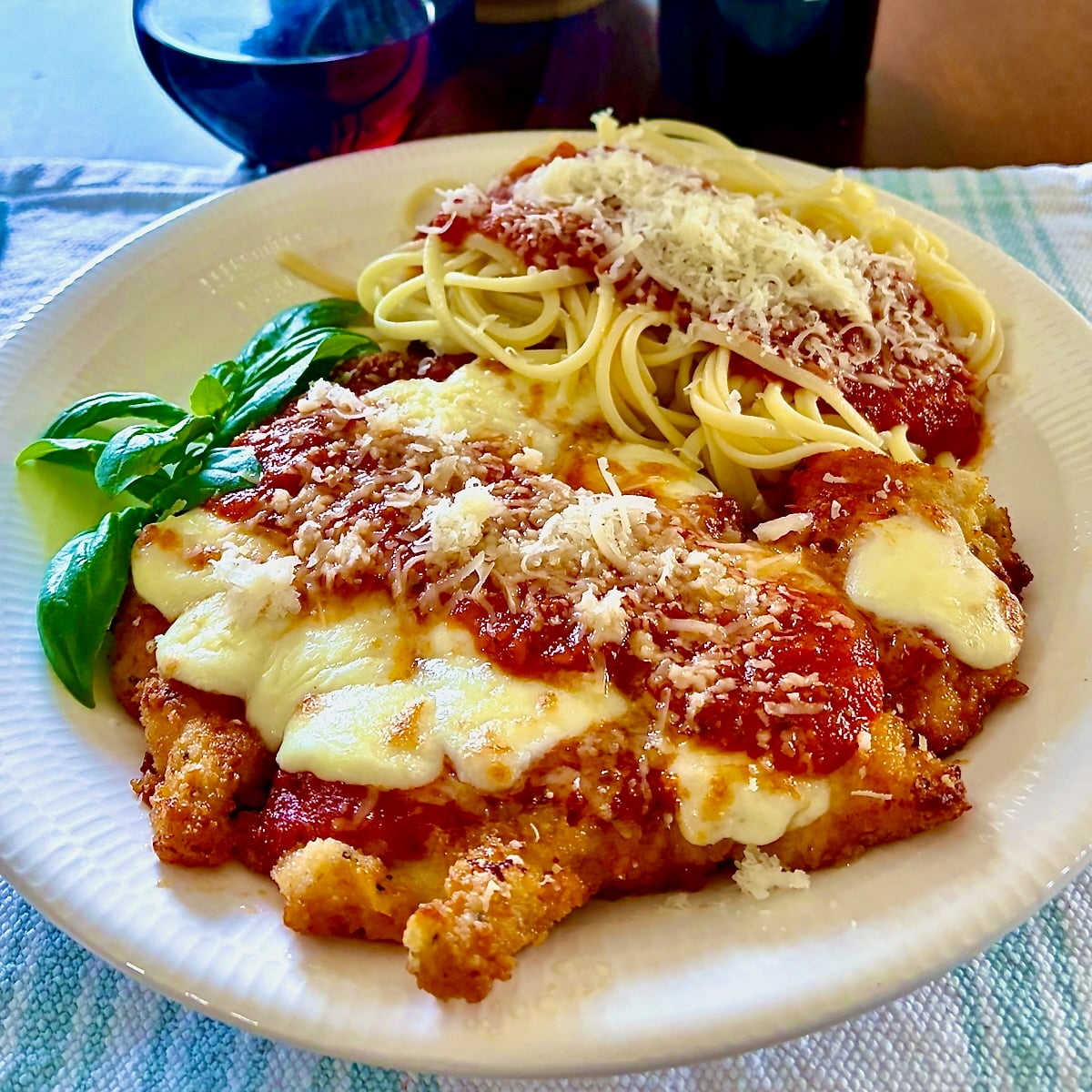 Easy 30 Minute Chicken Parmesan wide shot photo of one serving with linguine.