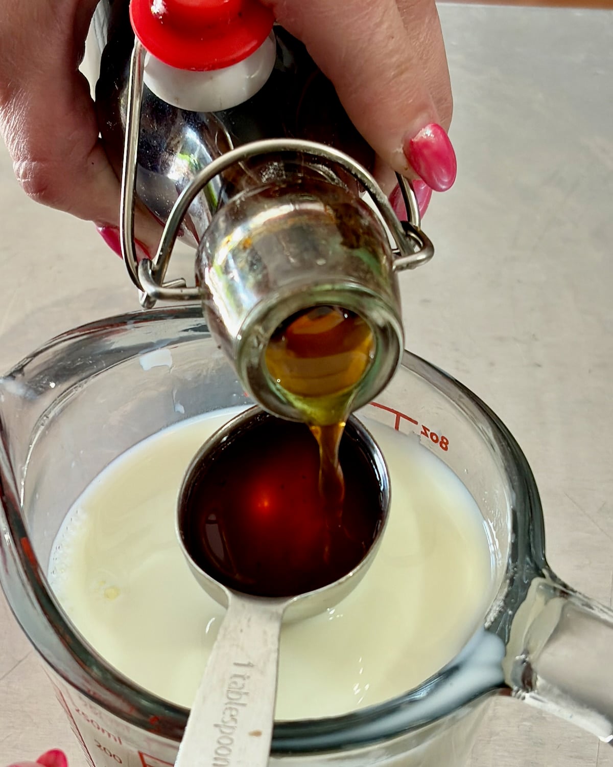 Photo of vanilla extract added to milk.