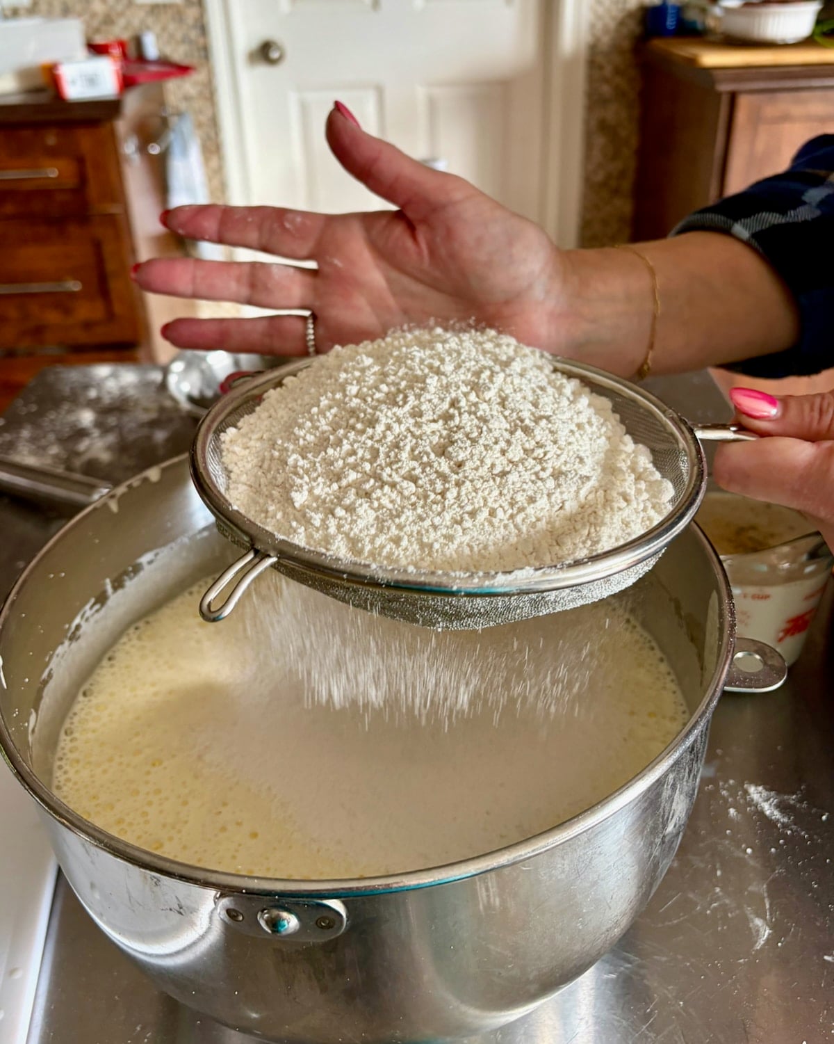Photo of flour and baking powder being sifted into the batter.