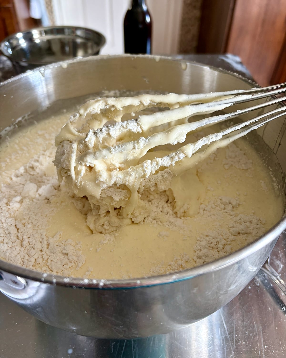 Photo of flour being folded in with a whisk.