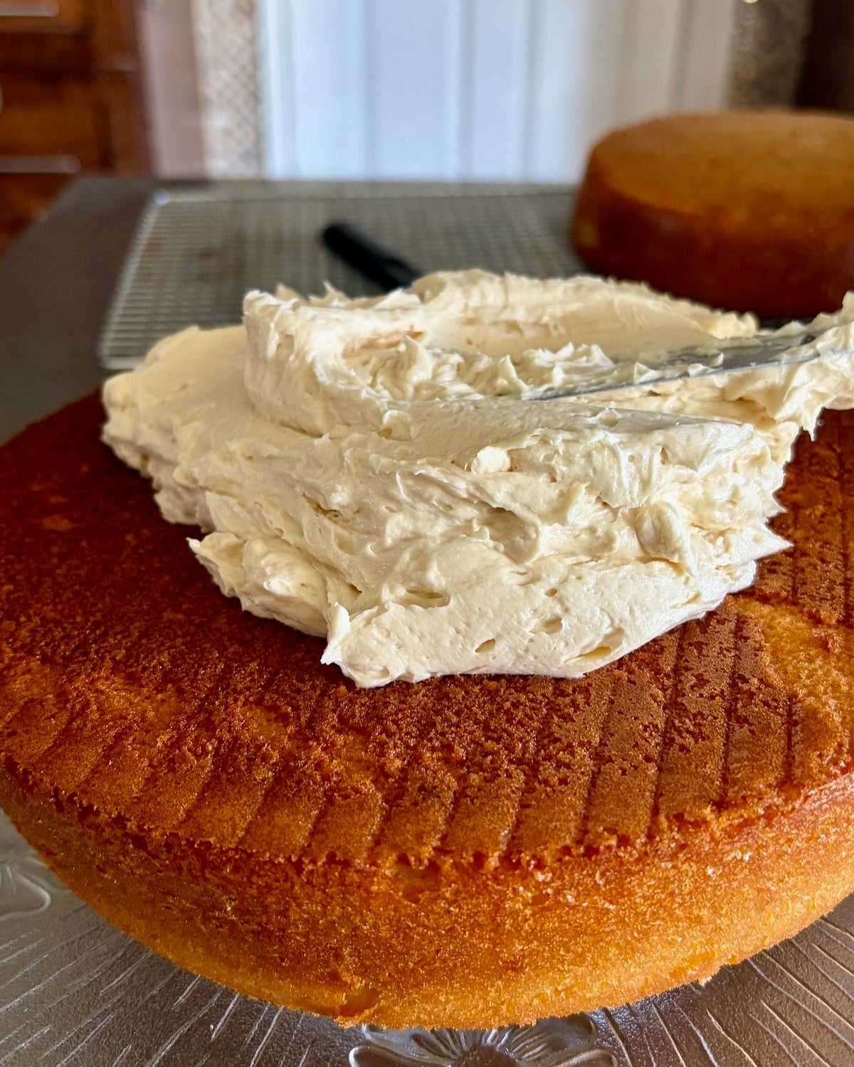 Photo of vanilla cake beginning to be frosted with Ermine Cream Frosting