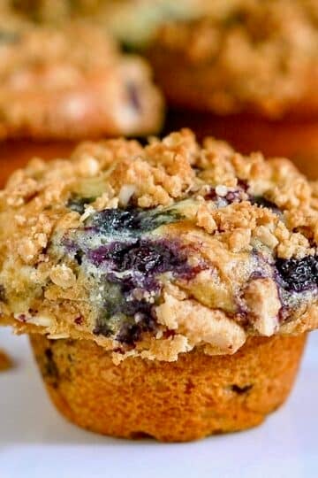 Lemon Blueberry Muffins with oatmeal almond streusel photo of a single muffin on a white plate