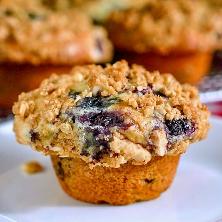 Lemon Blueberry Muffins with oatmeal almond streusel photo of a single muffin on a white plate
