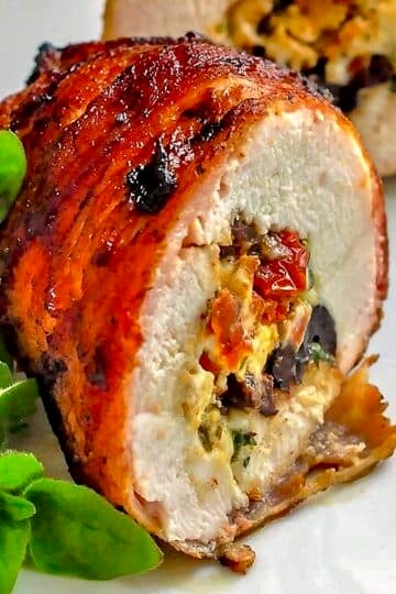 Bacon Wrapped Mediterranean Stuffed Grilled Chicken close up photo to show filling ingredients