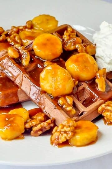 Chocolate Caramel Walnut Banana Waffles close up image on white plate.