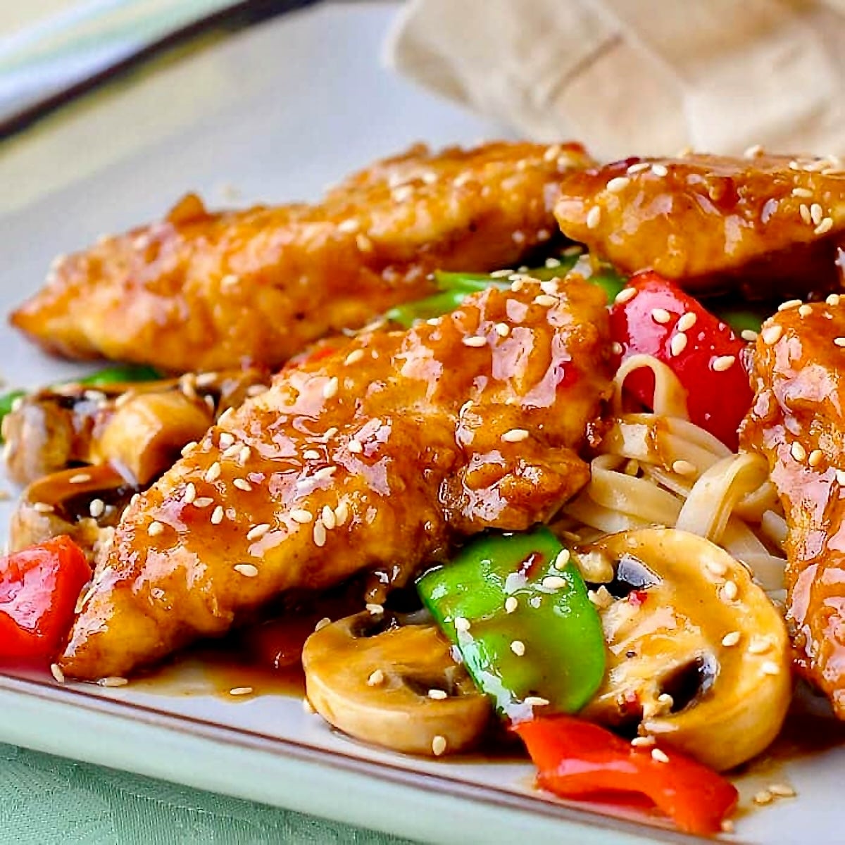 Crispy Oven Baked Low Fat Orange Hoisin Chicken shown on a square plate.