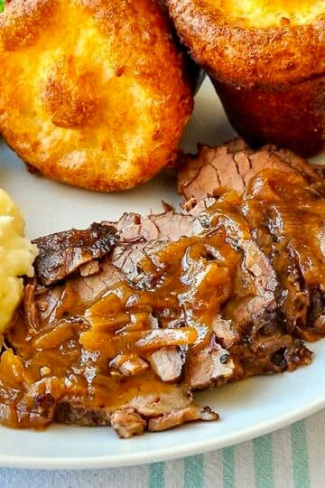 French Onion Braised Beef Brisket close up photo on white dinner plate for Google featured image.