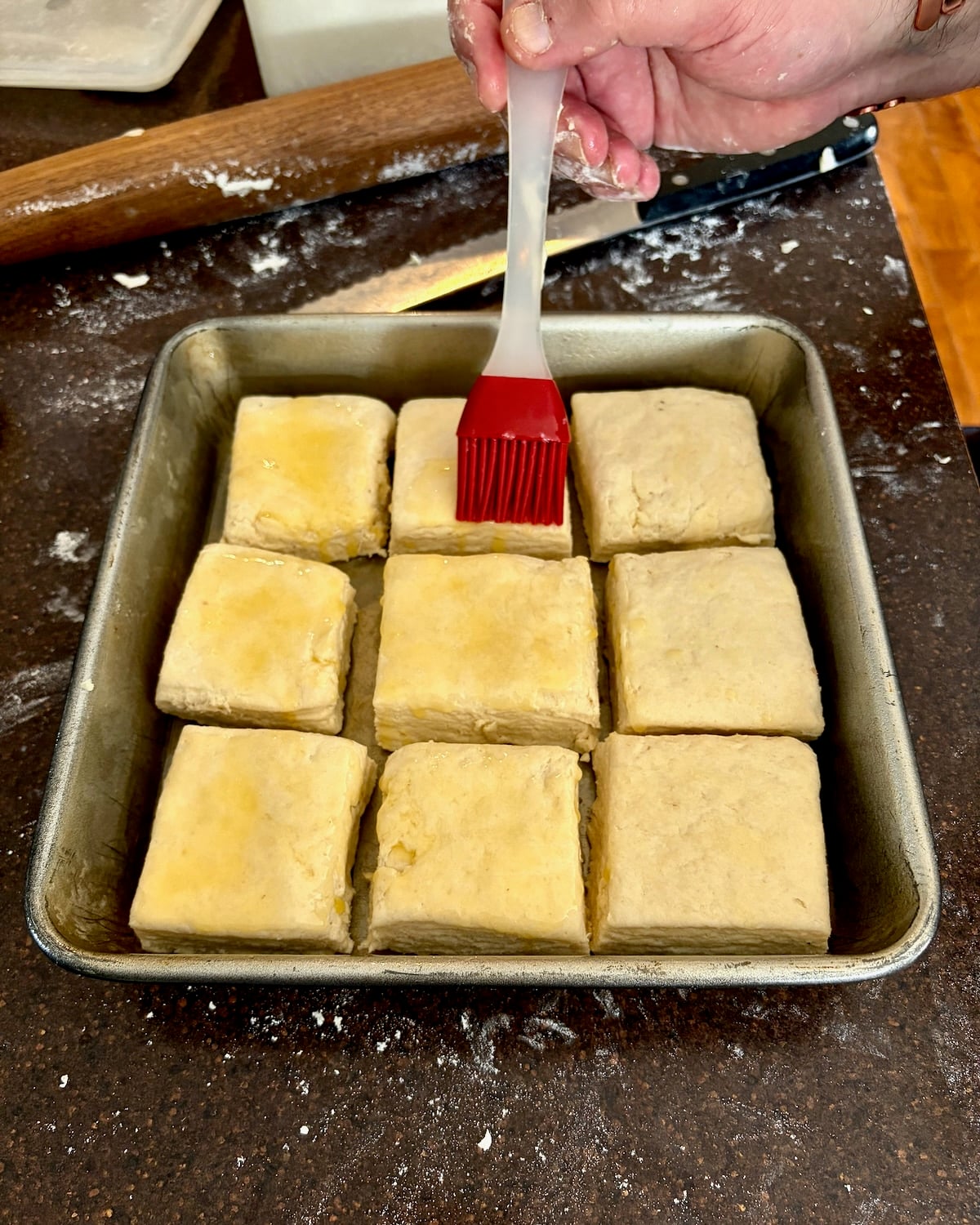 Photo of brushing butter onto Flaky Sour Cream Biscuits dough.