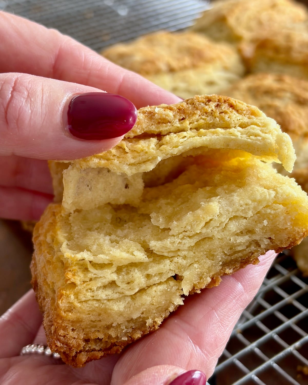 Photo of a Flaky Sour Cream Biscuits being pulled open to reveal layers.