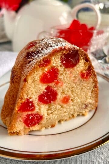 Close up photo of one slice of Swedish Berry Pound Cake on a gold and white plate for Google featured image