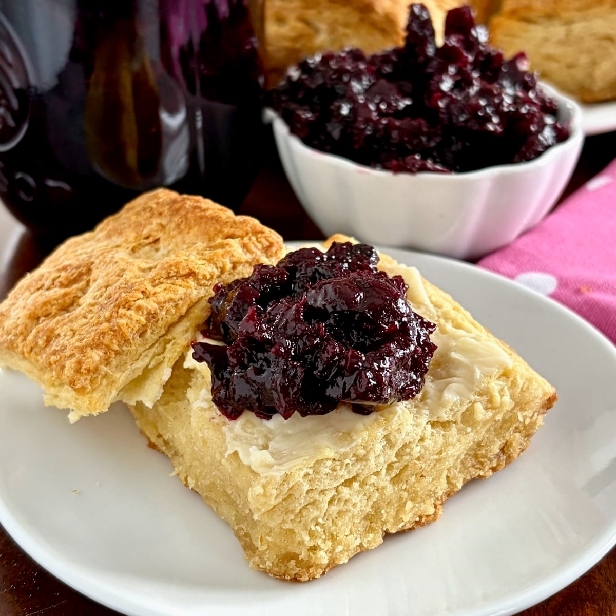 Close up photo of Low Sugar Blueberry Cherry Jam. on a biscuit.