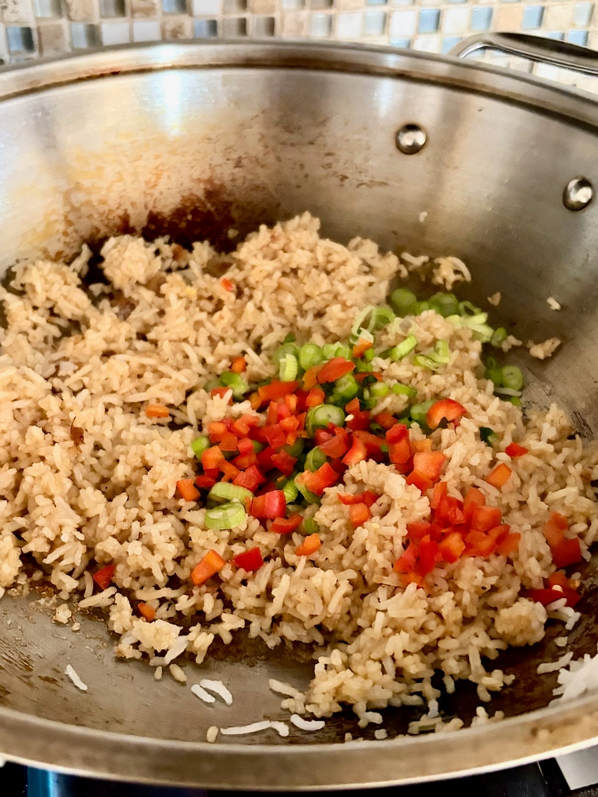 photo of peppers and green onion being added to the rice