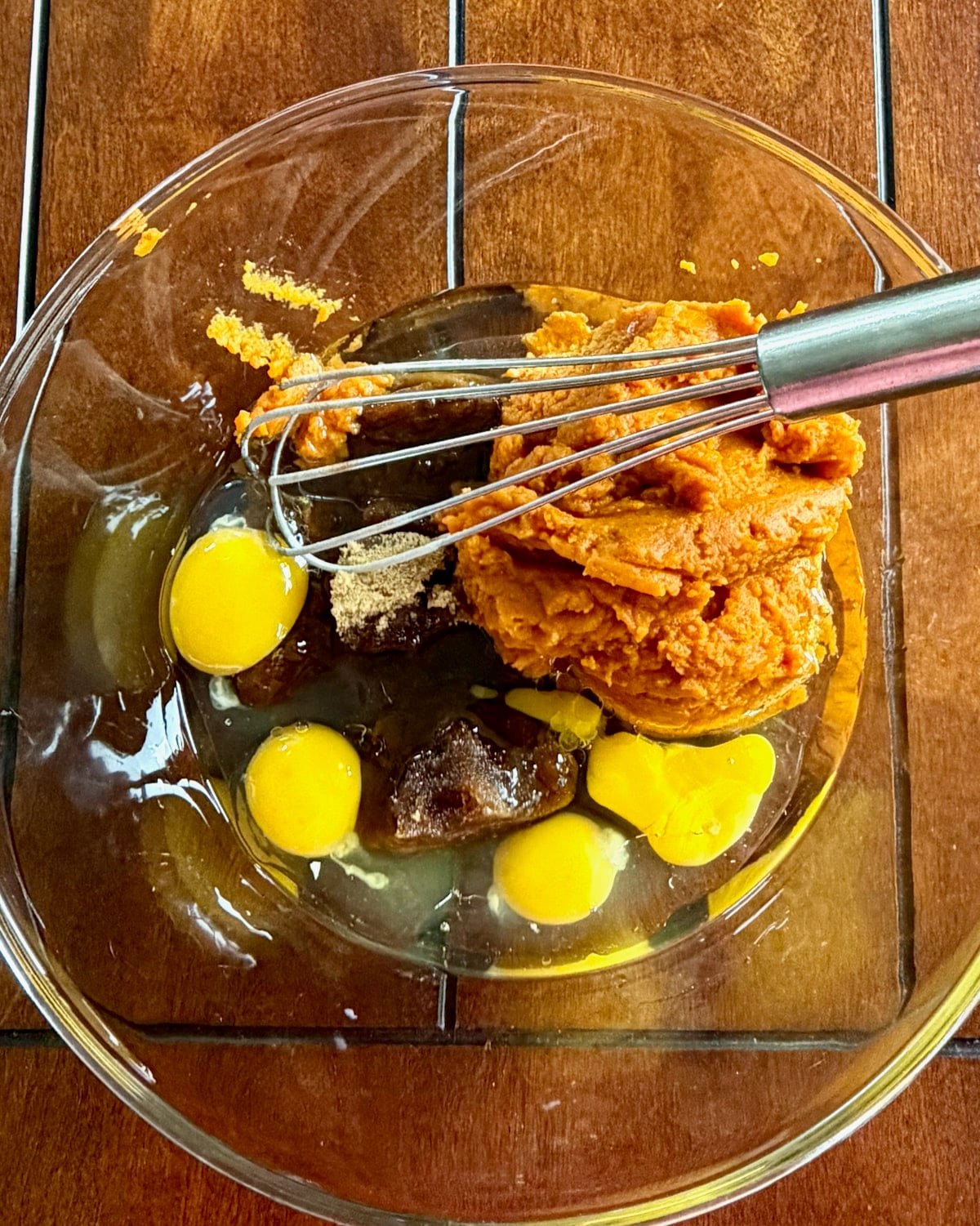 Photo of eggs, puree and oil in a glass bowl.