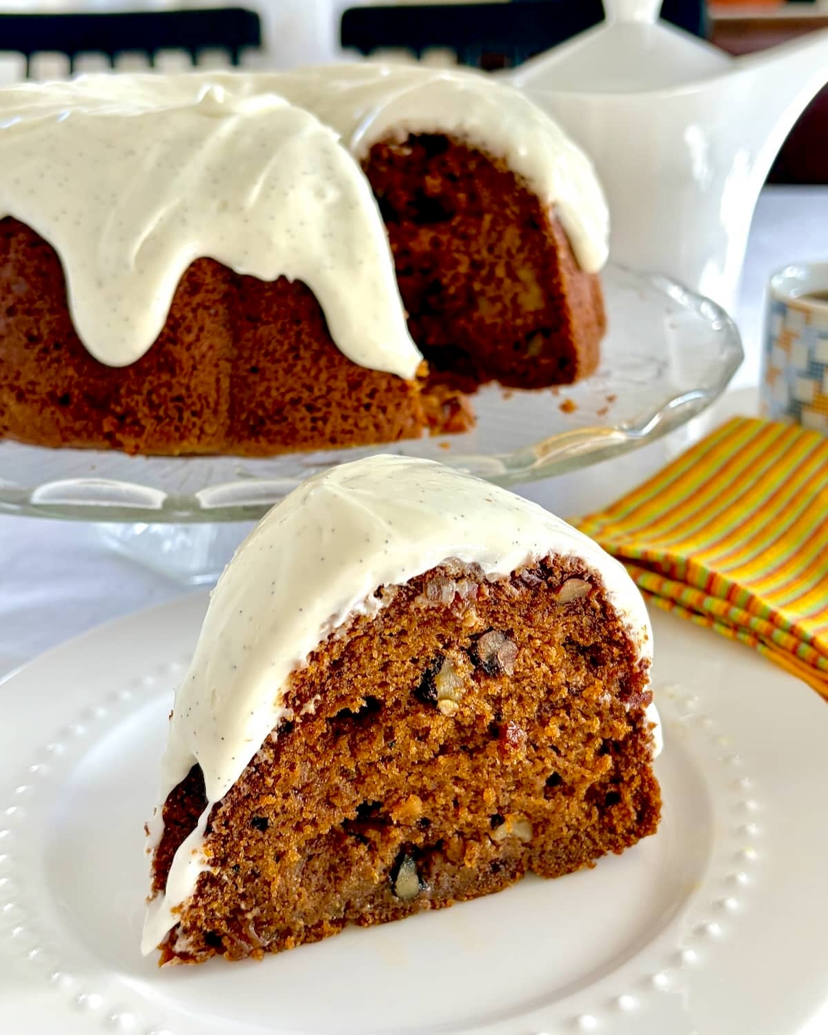 photo of one slice of Pumpkin Spice Walnut Cake with cut cake in background