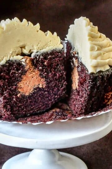 Inside Out Peanut Butter Cup Cupcakes close up photo of one cupcake cut open to reveal the chocolate frosting filling
